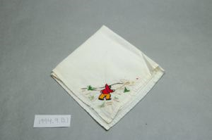 Image of Figure netting, one of a set of 2 embroidered napkins with scenes of Inuit figure at play